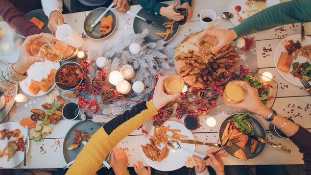 Un repas entre plusieurs personnes et d'une table bien garnie de nourriture et de décorations du temps des fêtes.