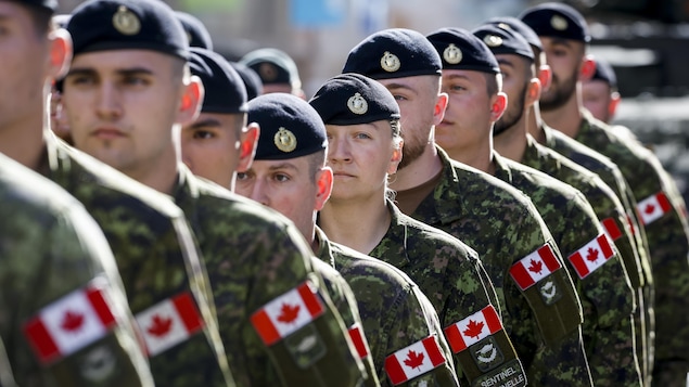 Des soldats canadiens postés les uns derrière les autres.
