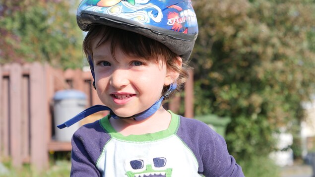 Un jeune garçon portant un casque de bicyclette.