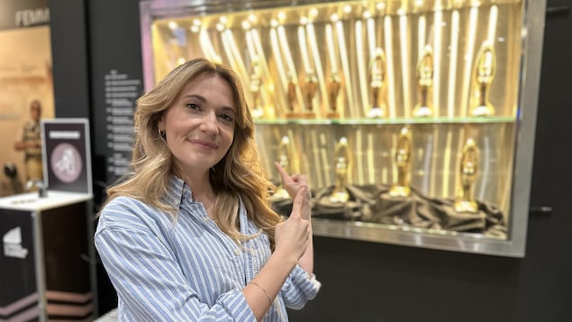 Rosalie Vaillancourt qui pointe un présentoir de trophées dans le foyer de la salle Odyssée à Gatineau.