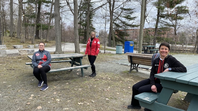 Les trois femmes sont assises dans un parc.