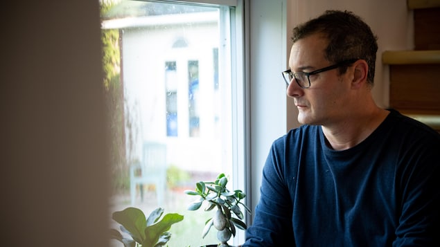 Sébastien Aubé regarde par la fenêtre, le regard triste.