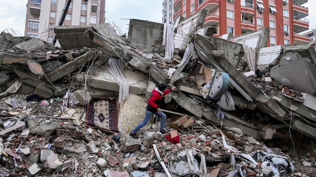 Un hombre entre los escombros tras un terremoto en Turquía.