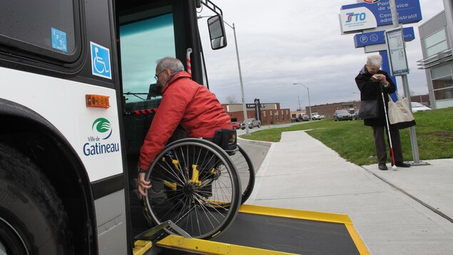 Un usager utilise la rampe d'accès d'un autobus de la Société de transport de l'Outaouais