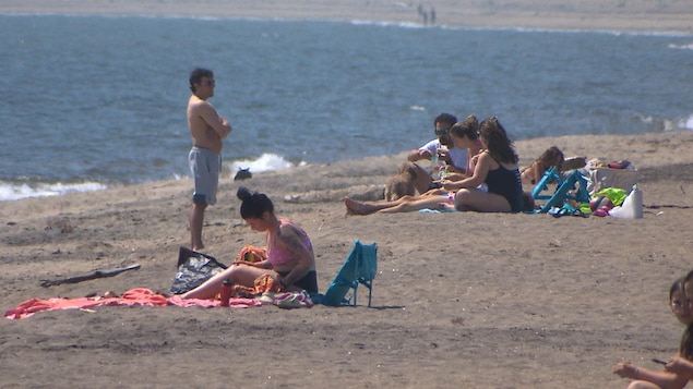 Des personnes en vacances qui profitent du beau temps sur la plage de Sept-Îles.