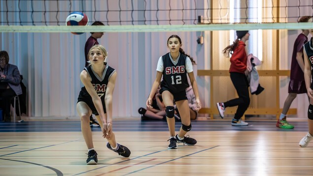 Une jeune joueuse de volley-ball va frapper un ballon.