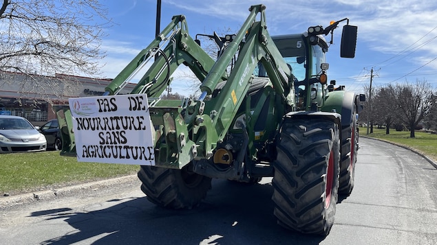 Un tracteur qui porte une affiche sur laquelle il est écrit « pas de nourriture sans agriculture.» 