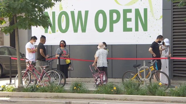 Des gens attendent dans une file.