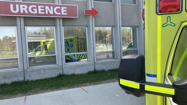 Une ambulance devant une enseigne d'urgence. 