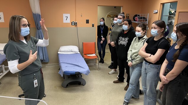 De jeunes étudiantes écoutent une travailleuse de la santé qui présente son département.