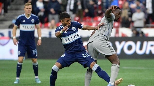 Deux joueurs de soccer tentent de maîtriser le ballon.