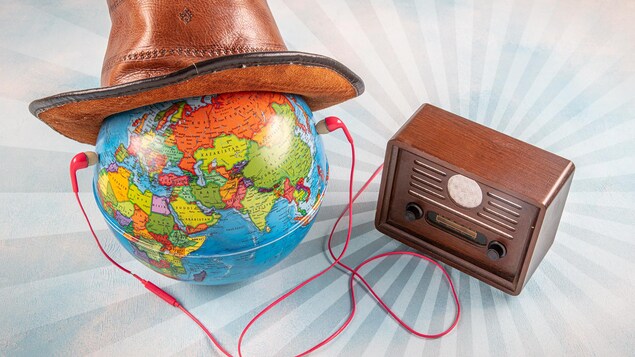 Un globe terrestre portant un chapeau relié à une radio par une paire d'écouteurs.