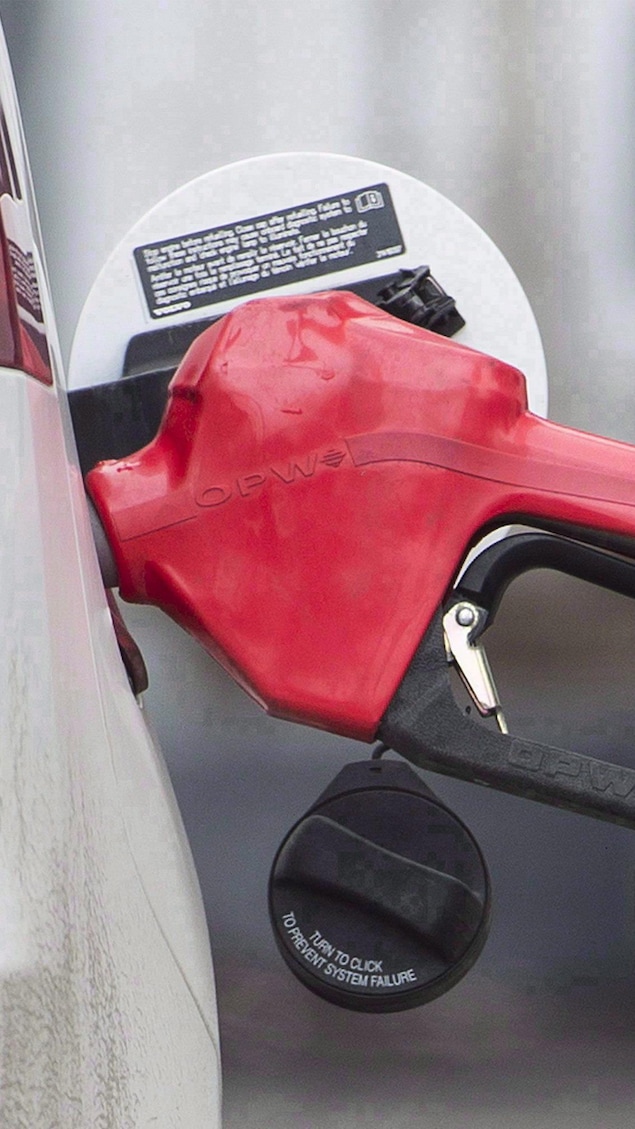 Un pistolet d'une pompe à essence dans une auto.