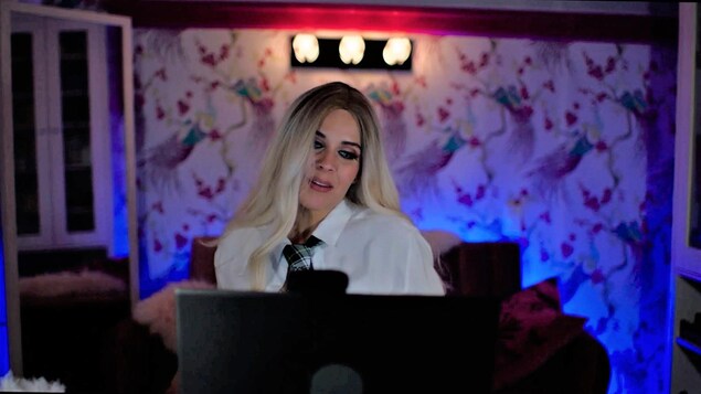 Elle est déguisée et maquillée devant son ordinateur alors qu'elle offre des services sexuels via webcam. 