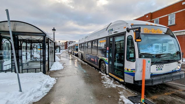 Des autobus arrêtés à un terminus au centre-ville de Trois-Rivières.