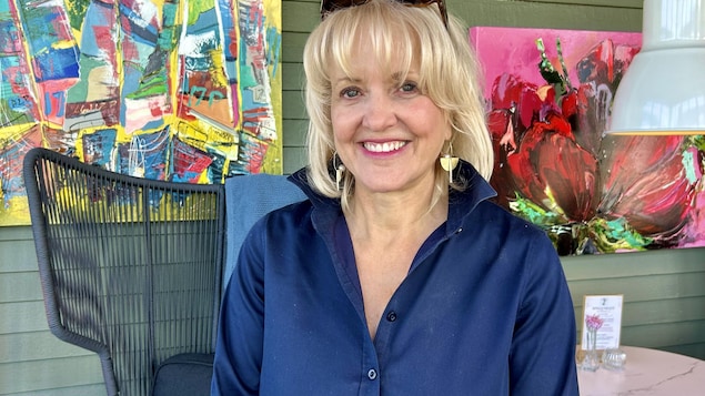 Lina Boudreau devant des œuvres d'art.