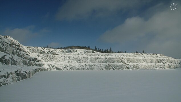 Une mine à ciel ouvert recouverte de neige.