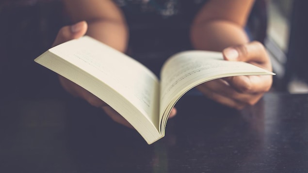 Une personne tien un livre ouvert dans ces mains