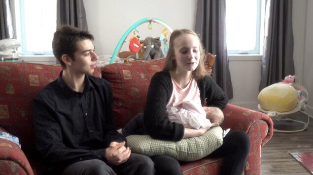 Sur un divan, Julianne allaite son bébé avec Laurent.