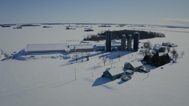Une ferme sous la neige, vue du ciel.