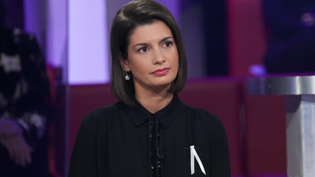 La femme est assise en studio.