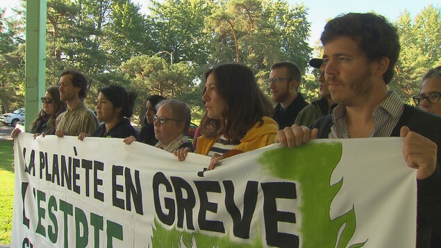 Des manifestants tiennent une bannière sur laquelle il est écrit : «planète en grève».