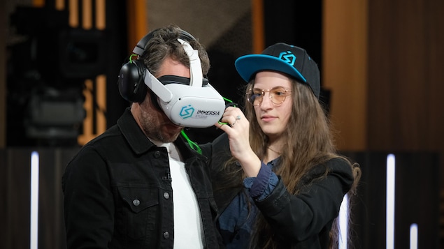 Une femme installe un casque de réalité virtuelle à un homme.