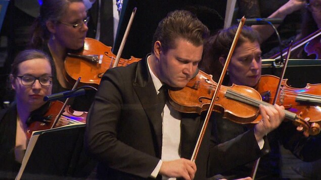 Alexandre Da Costa joue du violon sur scène avec un orchestre.