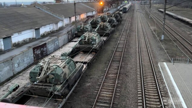 Des chars d'assaut sont en file dans une gare russe.