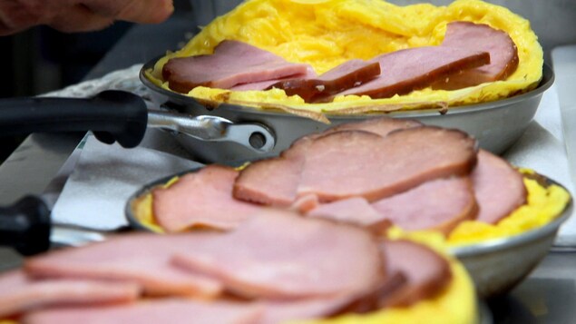 Des tranches de jambon toupie sont déposées sur des omelettes. 