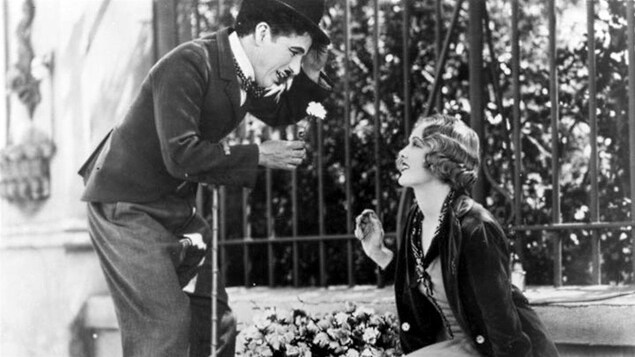 Charlie Chaplin offre une fleur à une femme dans Les lumières de la ville