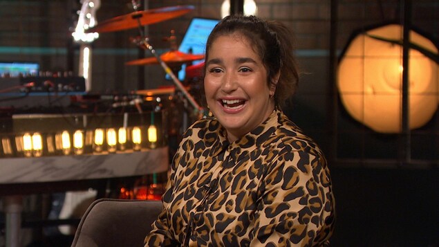 Elle est souriante dans une combinaison à motif léopard.