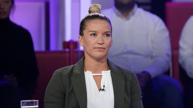 Une femme qui porte un chignon. Elle affiche un air sérieux.