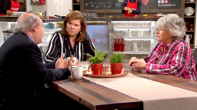Les trois sont assis à une table et discute. Marina regarde Michel Landry.