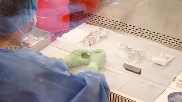 Personne qui manipule des médicaments en portant des gants de latex.