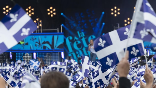 Une foule brandit des drapeaux du Québec devant la scène du spectacle du parc Maisonneuve.