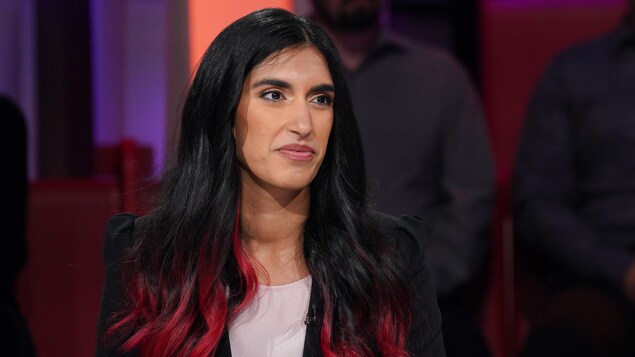 La femme est en studio et répond aux questions de l'animateur.