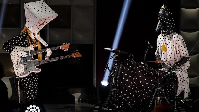 Les deux membres d'Angine de poitrine, déguisés, offrent une prestation dans le studio.