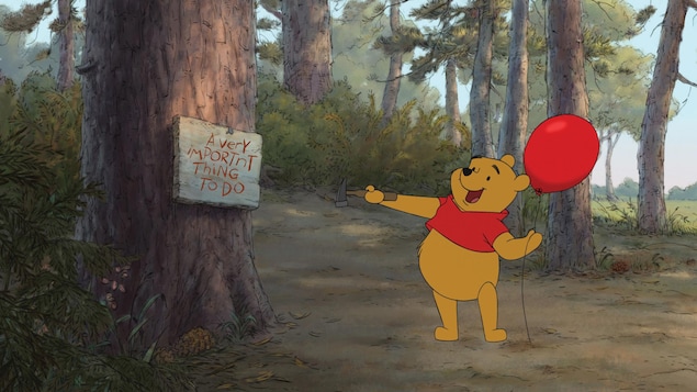 Un ourson dessiné porte un ballon rouge et un marteau dans ses mains, à l'orée de la forêt.