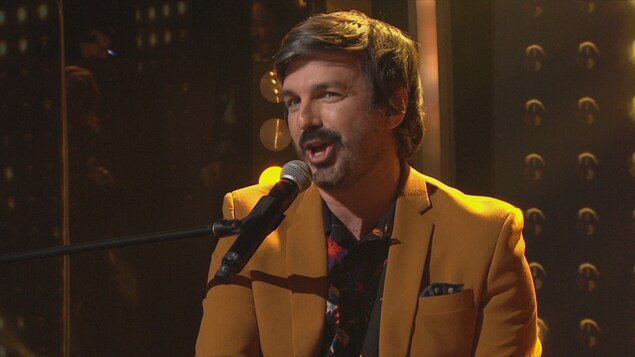 Il chante sur le plateau.