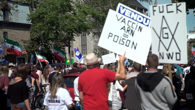 Manifestación de activistas antivacunas con pancartas.
