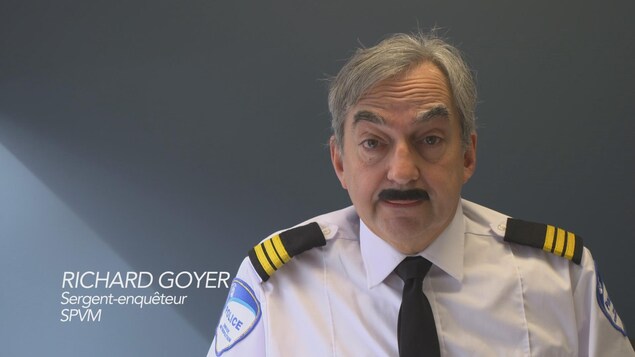 Un sergent moustachu face caméra en plan américain.