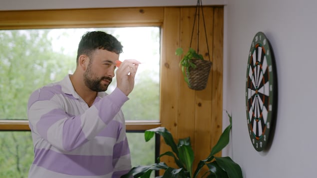 On voit l'animateur Félix-Antoine Tremblay qui joue aux fléchettes. 