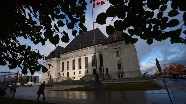 Un homme marche devant la Cour suprême du Canada.