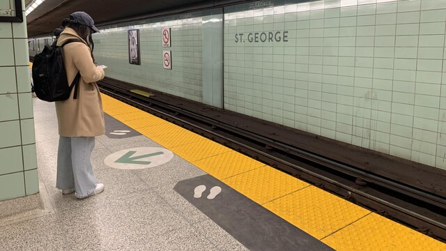Une personne attend le métro, seule sur le quai, à la station St. George, à Toronto.