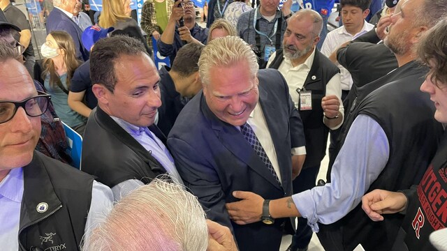 Doug Ford, entouré de ses gardes du corps, serre des mains à un événement partisan.