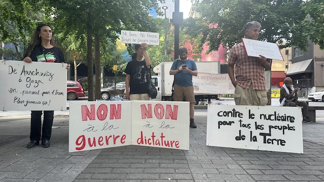 Des femmes et des hommes debout portant des pancartes.