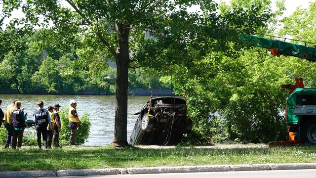 Des policiers et des secouristes récupèrent une voiture qui était tombée dans la rivière. 