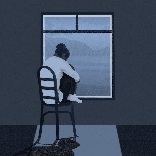 Une jeune femme, les jambes repliées sous elle, assise devant une fenêtre.