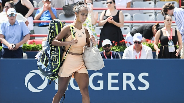 Une joueuse de tennis semble déçue en marchant sur le terrain.